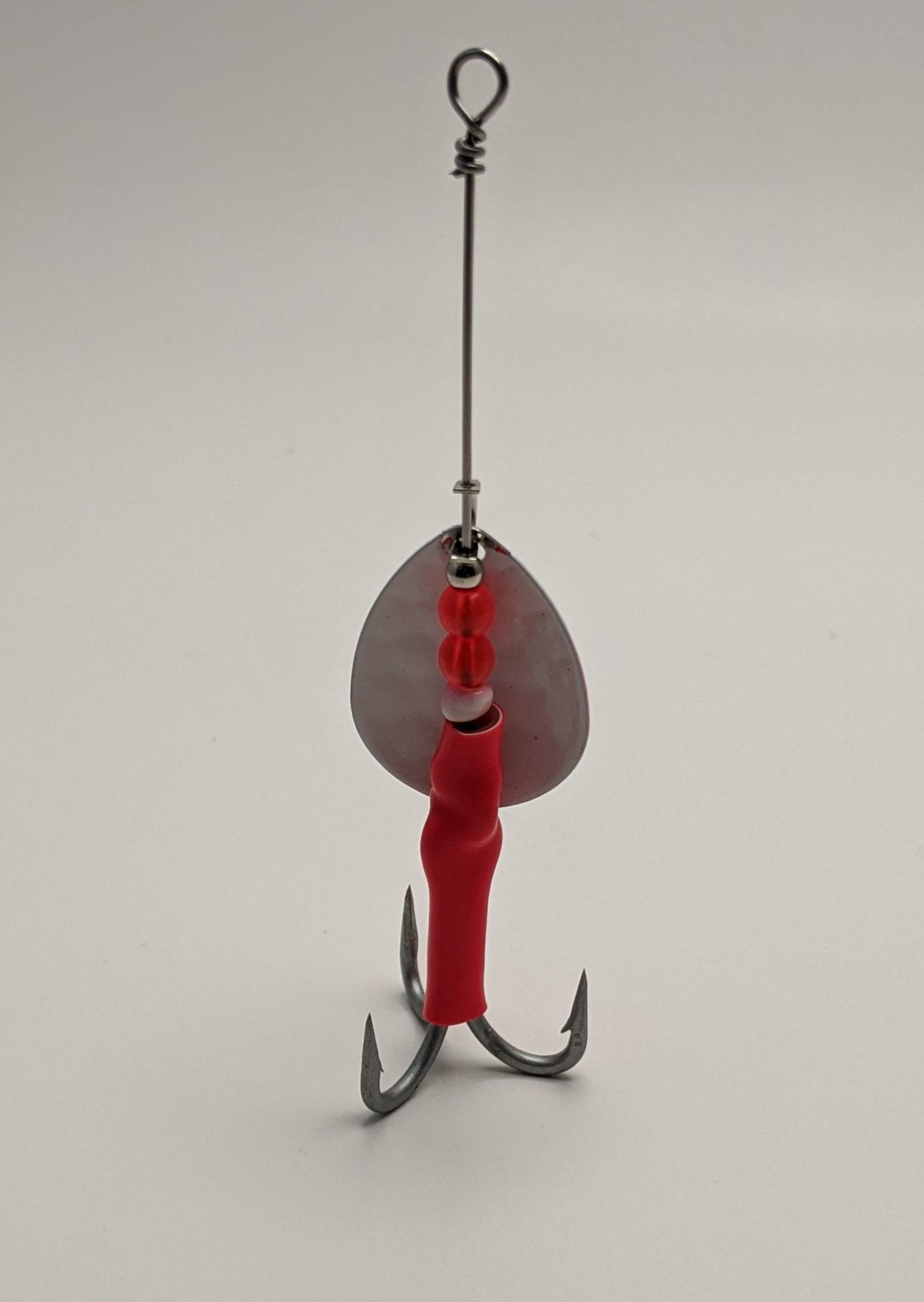 3.5 Colorado Spinner. Blade is white powder coated, front bottom half blaze orange. Flo red body, salmon beads with a Premium #2 permasteel VMC treble hook.